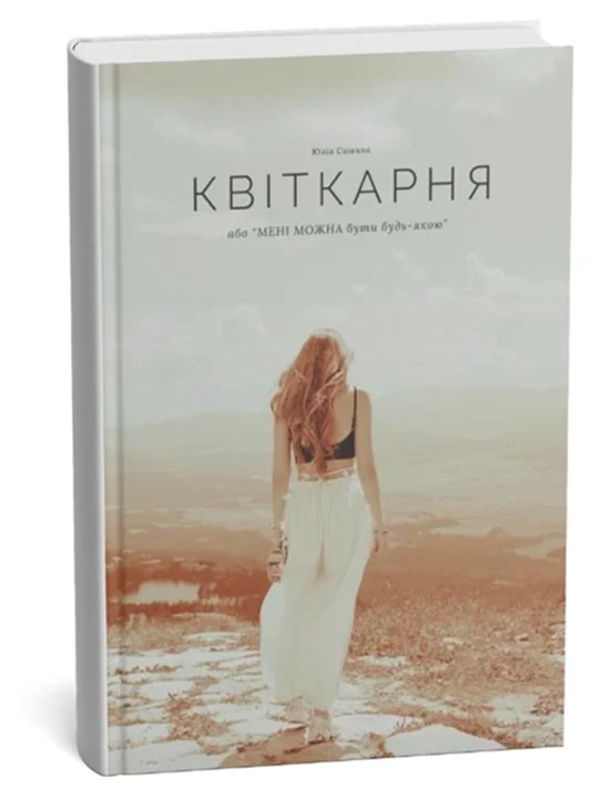 Макет книги «Квіткарня, або МЕНІ МОЖНА бути будь-якою» Юлії Сашиної — на обкладинці дівчина в білому йде теплим осяяним полем