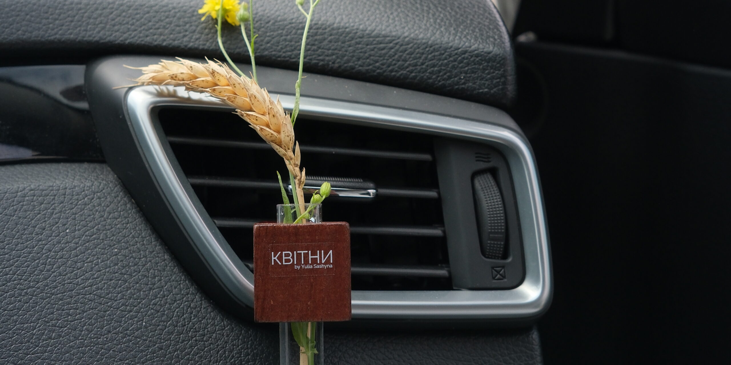KVITNY mini vase with wildflowers on a car air vent